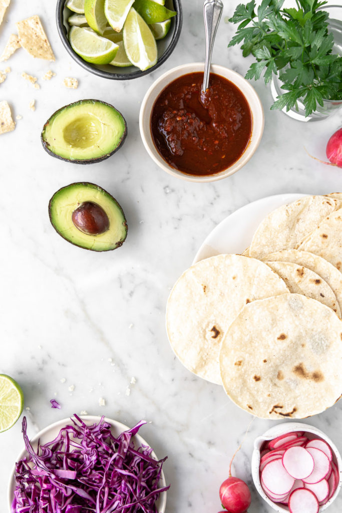 corn tortillas, cabbage, salsa, avocado, limes, cilantro, radishes