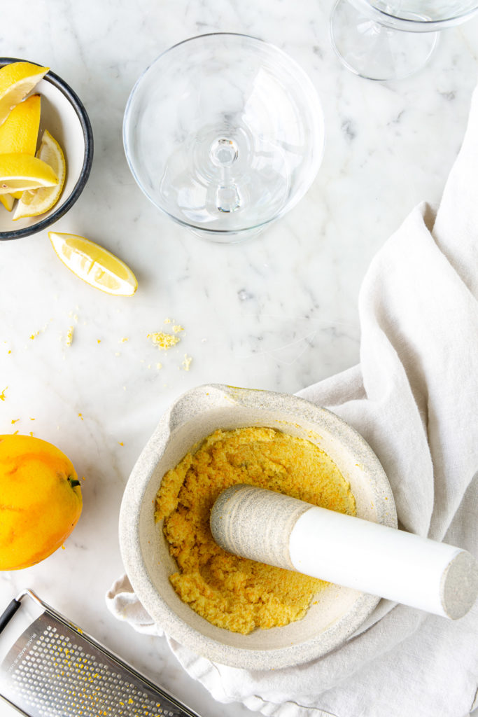 orange zest, sugar, mortar and pestle, prepared cocktail glasses