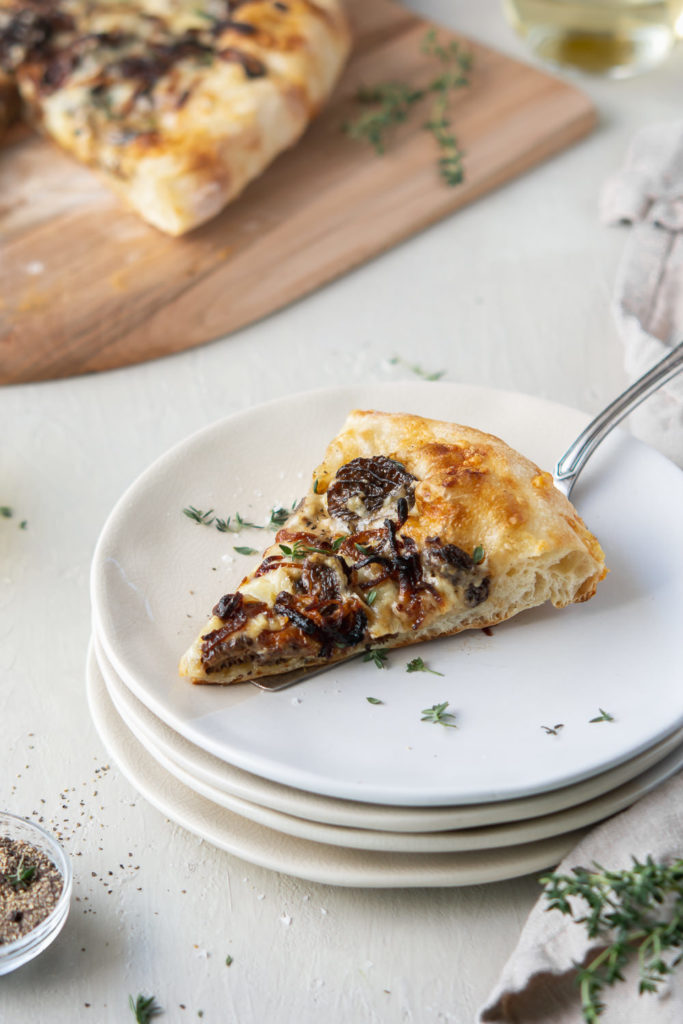 slice of morel pizza with creamy sauce, fontina cheese, parmesan and fried shallots