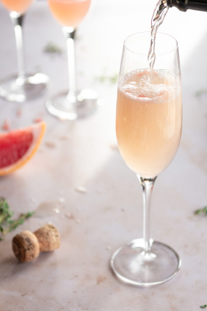 topping grapefruit mimosa with prosecco