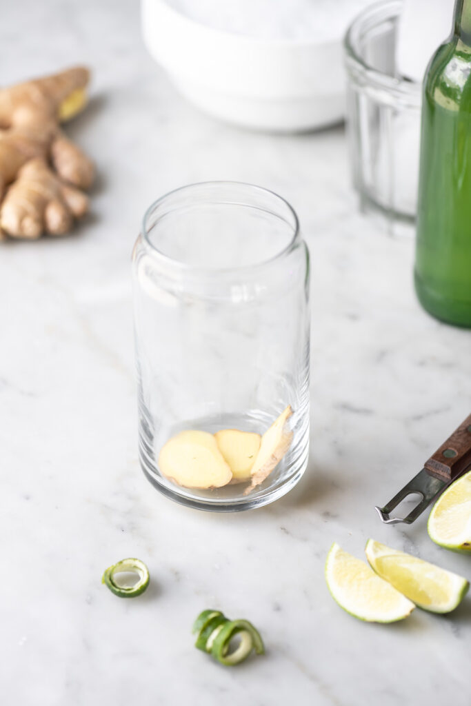 muddled ginger, citrus peeler, limes, crushed ice, blanco tequila, simple syrup, empty collins glass, ginger beer