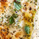 pizza with pools of garlic butter and herbs