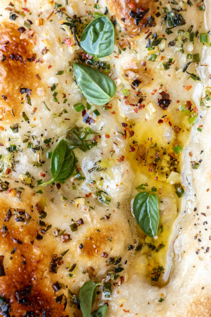 pizza with pools of garlic butter and herbs