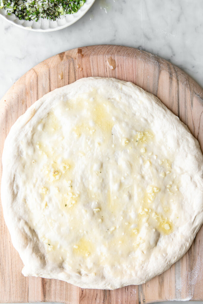 spread pizza dough with garlic butter sauce