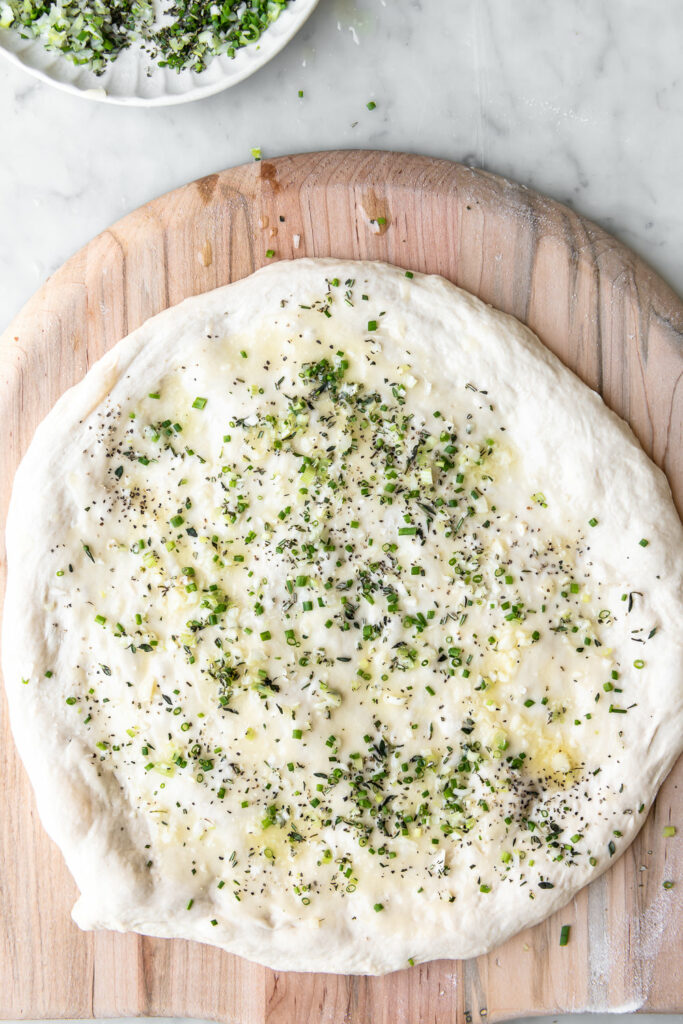 sprinkle garlic butter pizza dough with fresh herbs