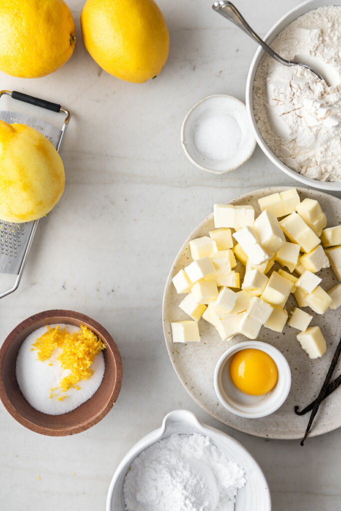 butter, lemons, sugar, powdered sugar, egg yolk, vanilla