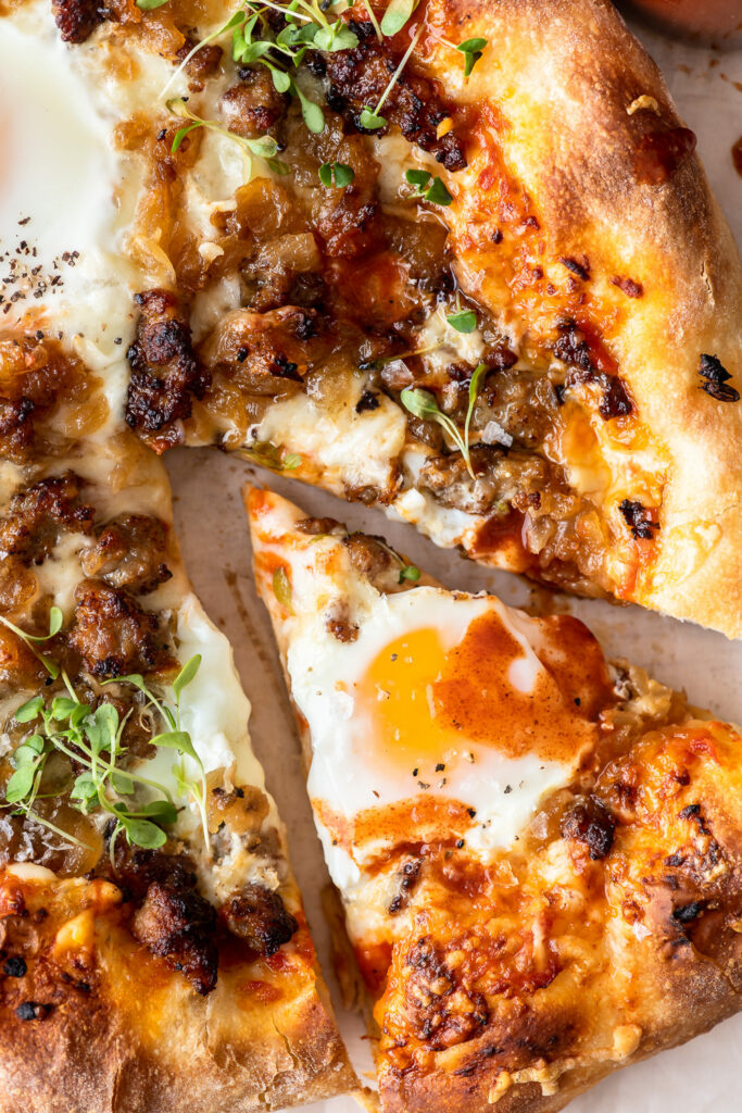 sausage breakfast pizza with eggs and caramelized onion