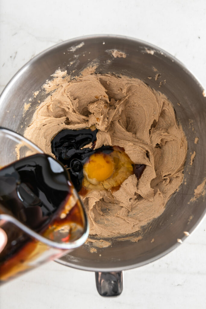 adding dark molasses to creamed butter