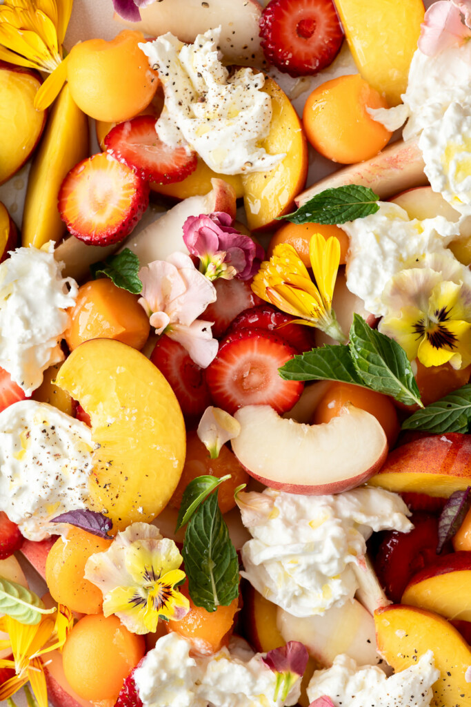 peach burrata salad with herbs and edible flowers